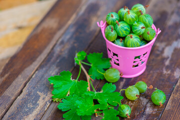 a handful of gooseberries on a wooden background