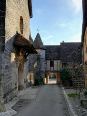 Balade dans une des rues du village de Loubressac avec le porche de l'église, dans le Lot