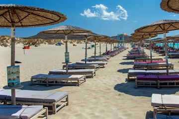 Beach umbrellas and deckchairs at the seaside in summer