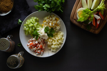 Crab salad with eggs, apple, crab sticks and celery dressed with mayonnaise, ingredients around, horizontal with copy space, top view © Diana