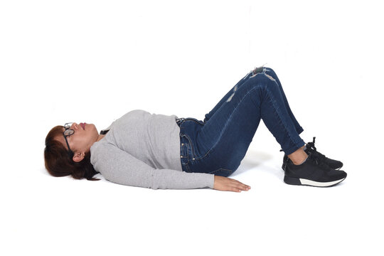 woman lying on the floor with her legs drawn up on white background