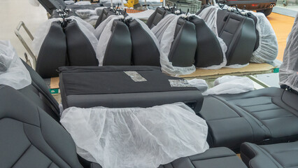 Fototapeta premium Car seats in the warehouse in the package. the car seat installation line is working.