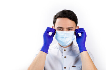 The guy in the medical gloves adjusts the protective mask. Young man during quarantine. Virus protection. Protection methods.