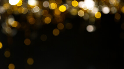 Abstract gold particles on black background, close-up.