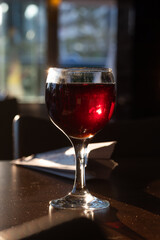 Glasses of white and red wine in a bar, man by the counter in the background