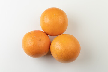 Three whole orange grapefruits isolated on white background, top view