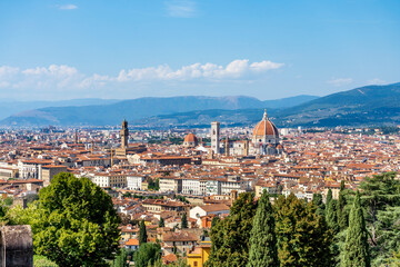 Scenic view of Florence from basilica of San Miniato, with cathedral on the background. Blue sky and a couple walking. Tuscany region, Italy.