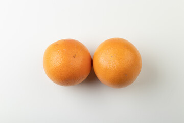 Two whole orange grapefruits isolated on white background, top view