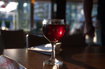 Glasses of white and red wine in a bar, man by the counter in the background