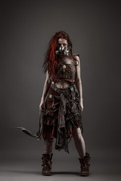 Attractive young woman with red eyes wearing post apocalyptic clothing and a gas mask