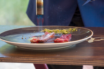 Chef cooking beef with a blowtorch in a Michelin-starred restaurant