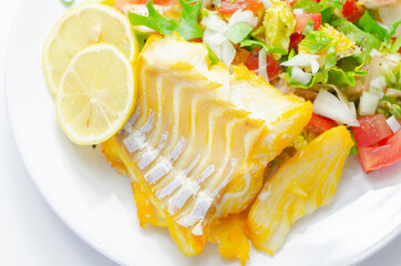 Smoked haddock fillet served with a fresh salad consisting of lettuce, tomatoes and onion