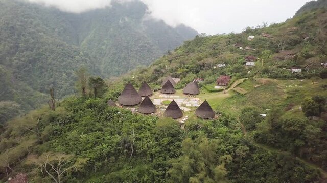 Aerial view of Traditional houses in Wae Rebo village in the jungle, Flores, Indonesia. Famous Manggarai's traditional villages, consist of 7 custom houses. 4K drone footage flying over the village.