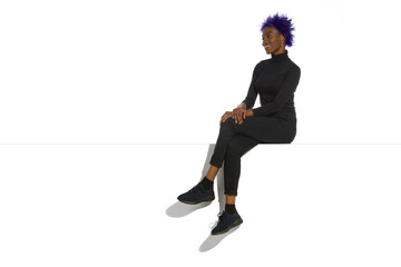 Beautiful Young Black Woman Is Sitting On A Top And Looking Away