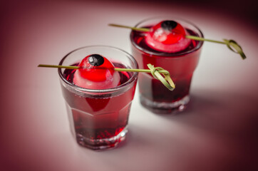Scary drinks shots made with tequila, grenadine and tabasco decorated with jelly eyeball