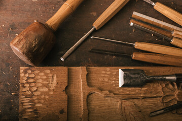 Aerial view of cabinetmaking tools next to a wood carving.