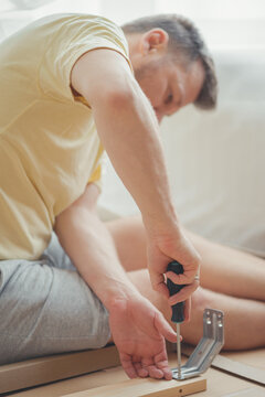 House furniture assembly process, hands of a man with a screwdriver