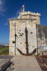 Old anchor on the side of the Saint-Nicolas tower in the city of La Rochelle in France