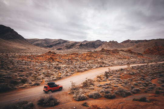 An orange car is on a road in Valley of Fire State Park
