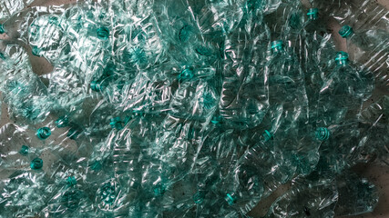 Pile of smashed plastic bottles laying on the floor landscape flat lay