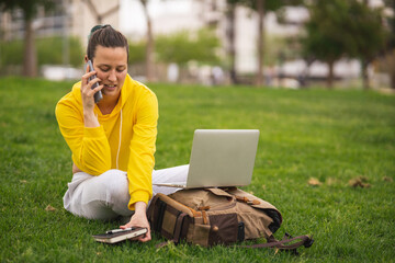 Spanish student talking on the phone while working with laptop