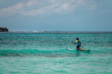 A surfer rides a board on the waves of the ocean. Water adventures in the tropics.