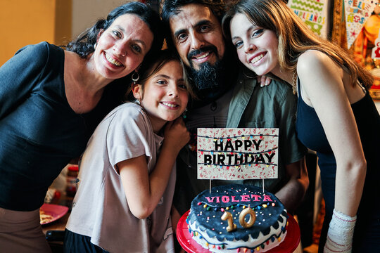 Portrait of a Latino family celebrating little girl's 10th birthday