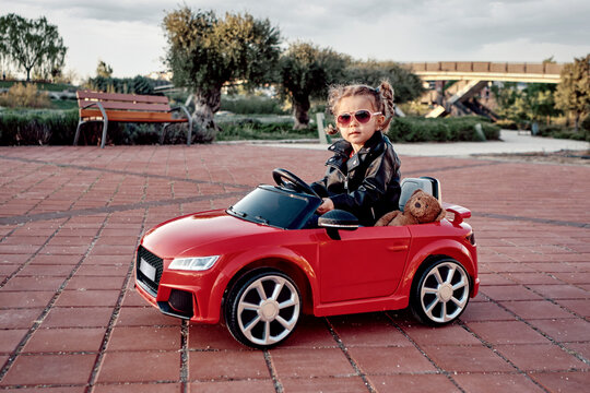 A girl riding a toy car