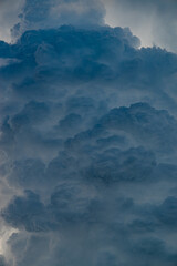 Huge and eerie cumulonimbus clouds rising in the summer sky