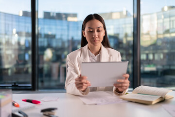 Asian businesswoman using tablet in office