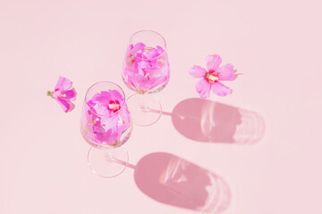 Summer creative composition made of two glasses with hibiscus flower water on pastel pink background.  Refreshment concept