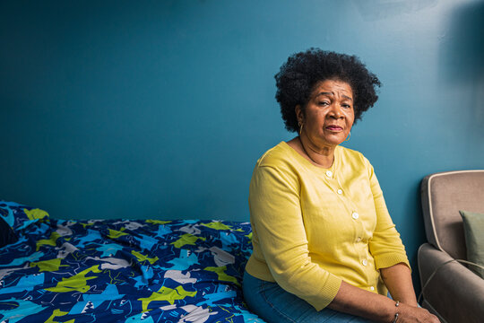 Portrait of serious senior woman sitting in bedroom at home