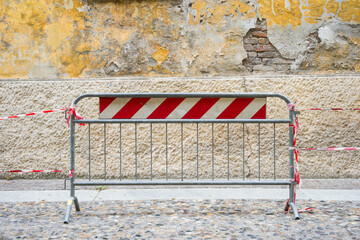 mobile metal barrier in the city street to delimit a crumbling wall
