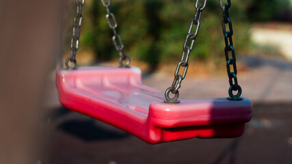 A red plastic swing in a park