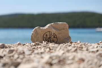 Stone with pictogram from numbers on the beach