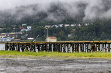 Fototapeta na wymiar High tide fluctuations occur in Juneau, Alaska with mist in the mountains