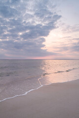 Warn and soft pastel-toned abstract seascape with gentle waves rolling in on the beach on Cape Cod