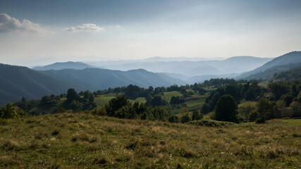 View of the slopes of the mountain Ozren, a hilly landscape with haze at horizon and mountain layers during sunny day