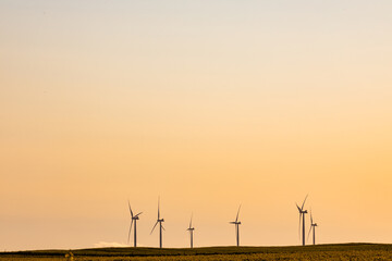 Obraz premium General view of wind turbines in countryside landscape during sunset