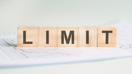 limit is written on light wooden blocks. the word is located on a sheet with charts and graphs