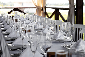 Banquet table in the restaurant, the preparation before the banquet. Empty glasses and plates.