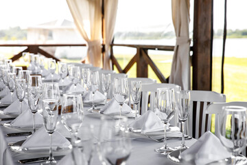 Banquet table in the restaurant, the preparation before the banquet. Empty glasses and plates.