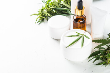 Cannabis cosmetic products. Natural cosmetic concept. Cream, soap, serum, essential oil and others with fresh hemp leaves.