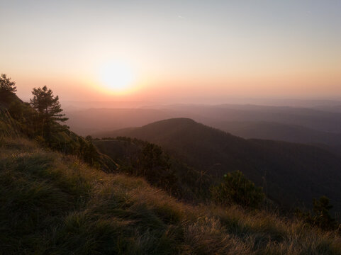 View of the slopes of the mountain Ozren from the peak Gostilj, a landscape of hilly Balkans with haze on the horizon at sunset