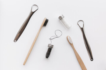 Dental hygiene set for couple. Bamboo toothbrush, dental floss and metal tongue scraper