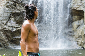 Fototapeta na wymiar Rear view of man looking the waterfall