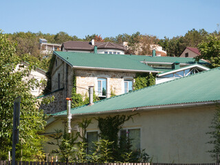 view of a house with a green roof in a seaside town. resort area, landscape with a house and mountains