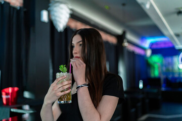 beautiful young woman having a drink in a pub