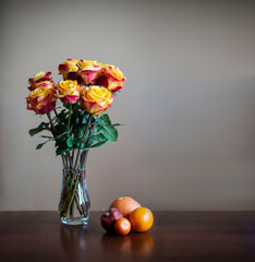 Roses and fruits naturemort in yellow and red colors