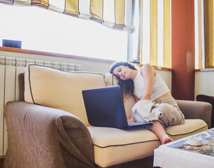 Obraz premium young woman with laptop working or studying on the sofa from home